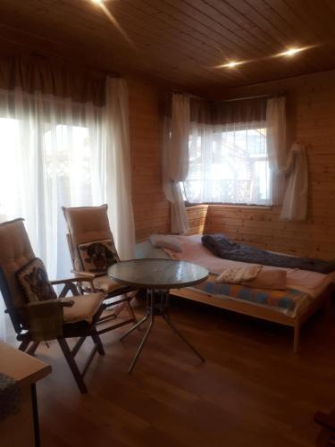 a living room with a bed and a table and chairs at Elżbieta in Pobierowo