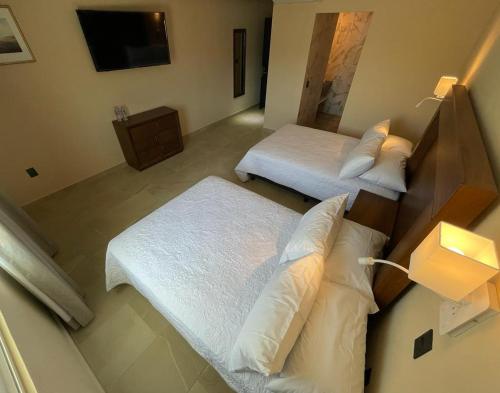 a hotel room with two beds and a television at Hotel Balcón del Cielo in Guanajuato