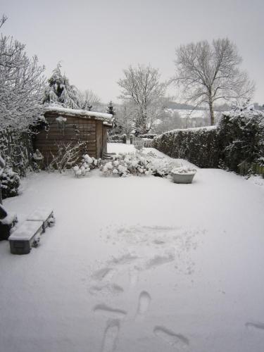 a yard covered in snow with a house at Hotel De Wilde Kriek in Valkenburg