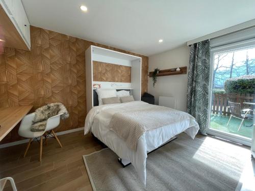 una camera con letto, scrivania e finestra di Le Cottage près Obernai a Klingenthal