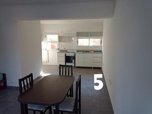uma cozinha com mesa e cadeiras num quarto em Duplex Houssay. em Aldea Camarero