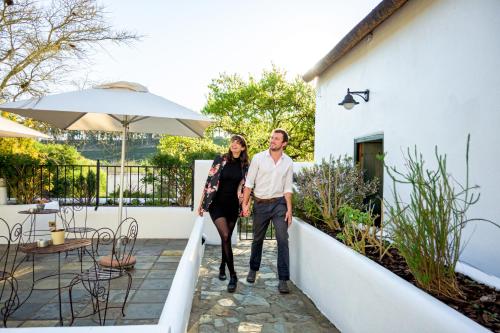 a man and woman walking down the stairs of a house at Tulbagh Boutique Heritage Hotel in Tulbagh