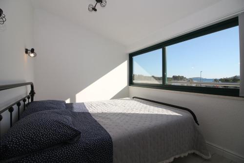 a bedroom with a bed and a large window at Apartments Fortunato in Zablaće