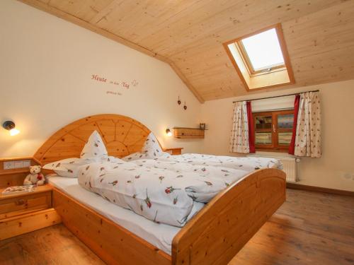 a bedroom with a large bed with a wooden headboard at Weissenhof - Chiemgau Karte in Inzell