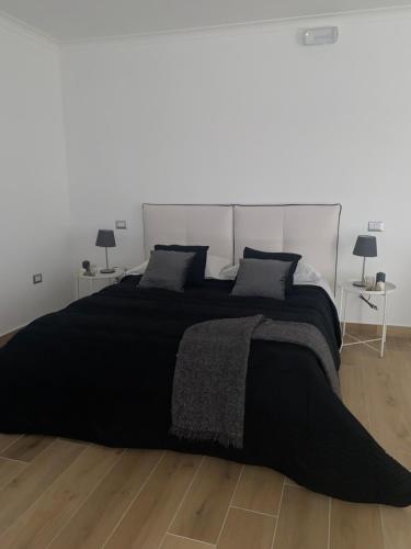 sypialnia z dużym czarnym łóżkiem z 2 lampami w obiekcie Pvteoli Suite w mieście Pozzuoli