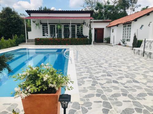 a villa with a swimming pool in front of a house at Hermosa Casa de campo grande con aire acon,wifi,piscina,billar !villa ensueño ! in Carmen de Apicalá