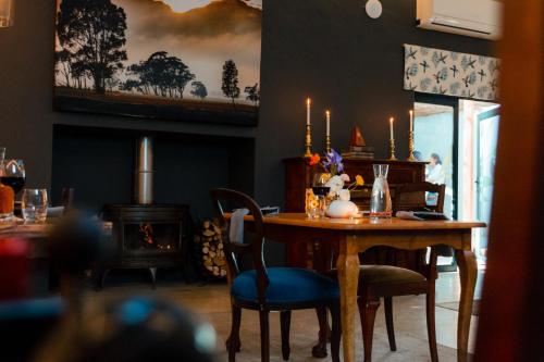 a dining room with a table and chairs and a fireplace at Tulbagh Boutique Heritage Hotel in Tulbagh