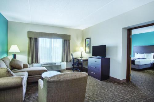 a hotel room with a bed and a living room at Comfort Inn & Suites Sarasota I75 in Sarasota