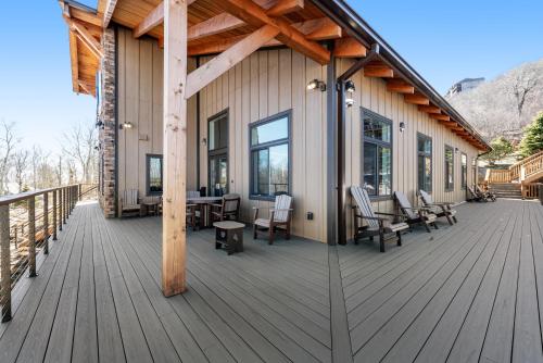 a large wooden deck with chairs and a table at Sugar Ski 613 in Sugar Mountain