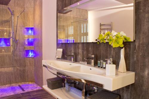 a bathroom with a sink and a mirror at Liberty at Utopia Penthouse by MGroupSA in Swansea