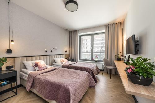 a hotel room with two beds and a window at Apartament Moje Miasto in Gdynia