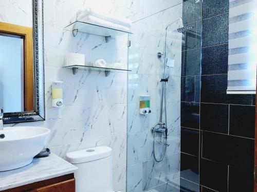 a bathroom with a shower and a toilet and a sink at Gaia Residence Deluxe in San Felipe de Puerto Plata