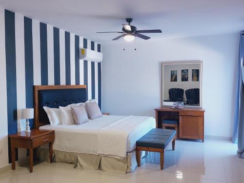 een slaapkamer met een bed en een plafondventilator bij Gaia Residence Deluxe in San Felipe de Puerto Plata