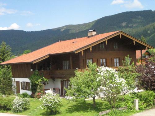 een groot houten huis met bergen op de achtergrond bij Ferienwohnung Gundi Scheurl - Chiemgau Karte in Inzell