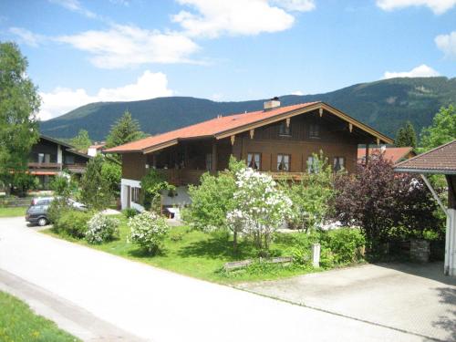 een huis op een straat met bergen op de achtergrond bij Ferienwohnung Gundi Scheurl - Chiemgau Karte in Inzell