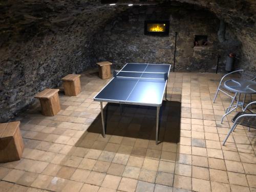 a ping pong table and benches in a room with a stone wall at Egrensis Apartments in Loket