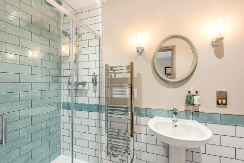 a bathroom with a sink and a shower with a mirror at Charlcombe Inn in Bath