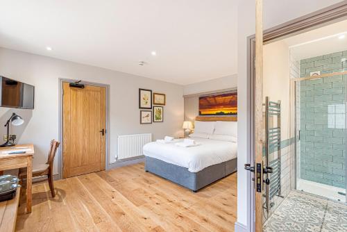 a bedroom with a bed and a desk and a bathroom at Charlcombe Inn in Bath