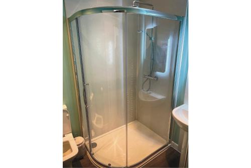 La salle de bains est pourvue d'une douche avec une porte en verre. dans l'établissement Feorline Cottage, à Lochgoilhead