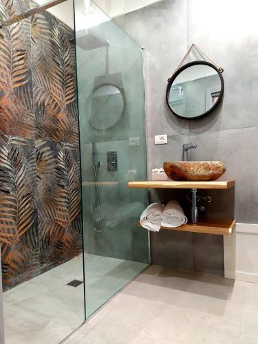 a bathroom with a shower with a sink and a mirror at Masseria Torre Saracena in Agrigento