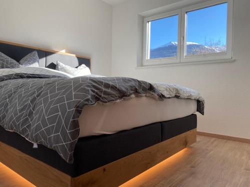 a bedroom with a bed and two windows at Alpenlodge Pitztal in Wenns