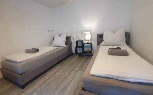 two beds sitting in a room with wooden floors at Neuburg City Apartments in Neuburg an der Donau