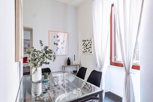 een witte woonkamer met een glazen tafel en stoelen bij Monserrato Historical by Campo de' Fiori in Rome