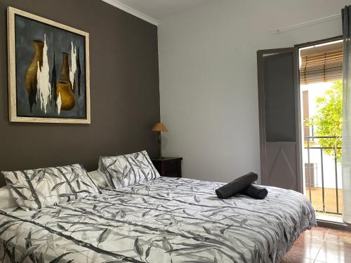 a bedroom with a bed and a painting on the wall at Casa Ohana in Algodonales