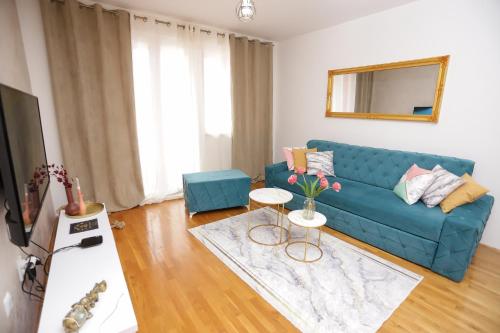 a living room with a blue couch and a mirror at Apartman Cezar Lukavica in Lukavica