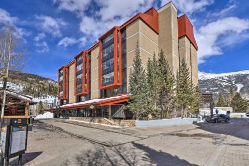 a building with a snow covered mountain in the background at Copper Mountain Condo Walk to American Eagle Lift in Copper Mountain