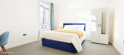 a bedroom with a bed and a window at Marigold Villa in Harrow
