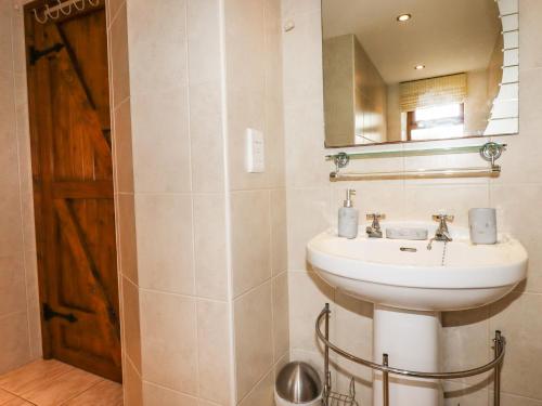 un baño con lavabo y espejo en Brocks Barn, en Lanlivery