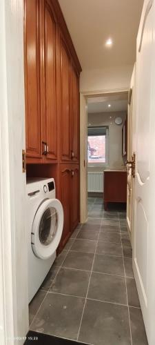 a bathroom with a washing machine in a room at Marigold Villa in Harrow