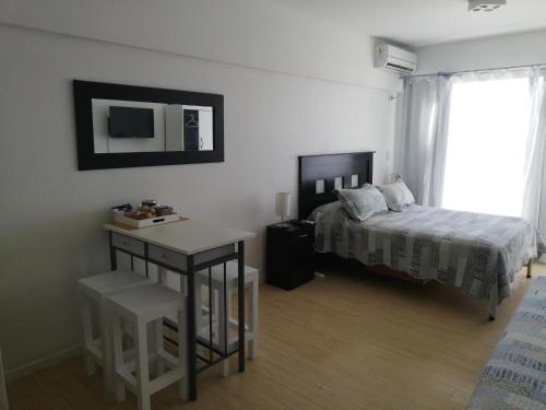 1 dormitorio con cama, mesa y escritorio en AiresSoho1160 en Buenos Aires