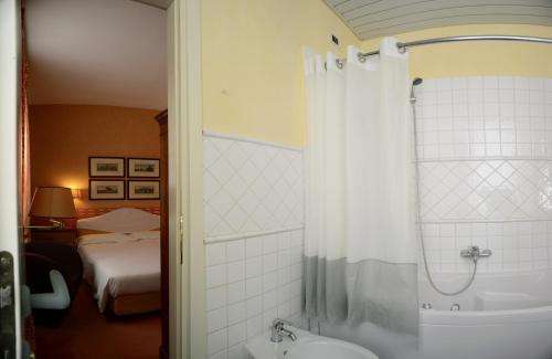 bagno con vasca, doccia e lavandino di Hotel Colombia a Trieste