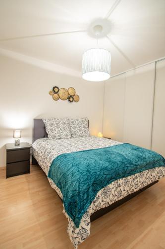 une chambre avec un lit avec une couette verte dans l'établissement Le Paisible T2-48m2-Proche Val d'Europe-Disney, à Montévrain