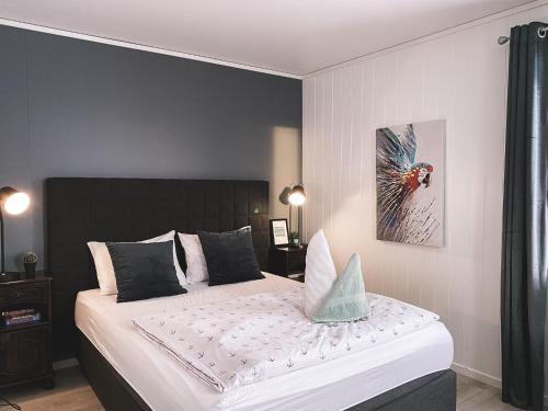 a bedroom with a large bed with a black headboard at Lille Chili Eat and Sleep AS in Jakobselv