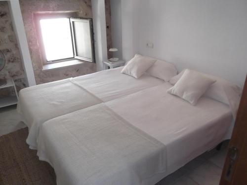 - un lit blanc dans une chambre avec fenêtre dans l'établissement Can Tianyico, à Sa Pobla