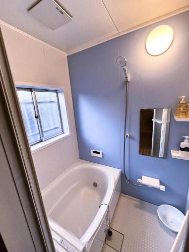 a bathroom with a bath tub and a sink at Nara Park Blue Sky in Nara