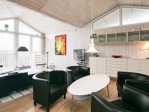 ブロックフスにある6 person holiday home in Blokhusのリビングルーム(白いテーブル、黒い椅子付)