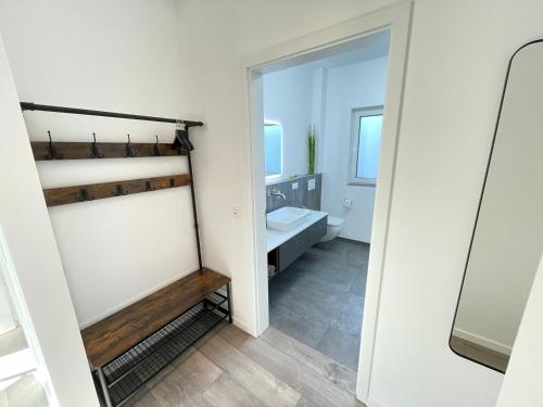 a white bathroom with a toilet and a sink at Lee-Moderne Neubauwohnung in Strandnähe - Wallbox in Wremen