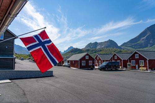 a norwegian flag hanging on the side of a house at Lofoten Cabins - Kåkern in Ramberg