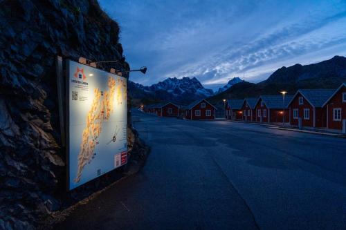 a sign on the side of a street with houses at Lofoten Cabins - Kåkern in Ramberg