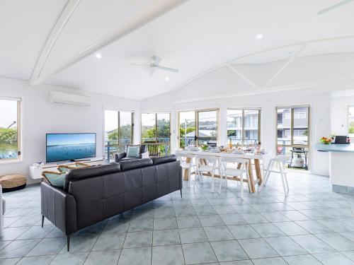 a living room with a couch and a table at Baia Villa air con WiFi and views of Fingal Beach in Fingal Bay