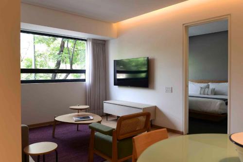 a hotel room with a bed and a table and chairs at V65 Mx in Mexico City