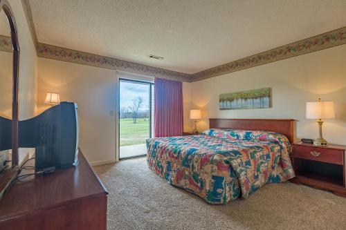 a bedroom with a bed and a tv and a window at Crown Resorts at Lake Tansi West in Crossville