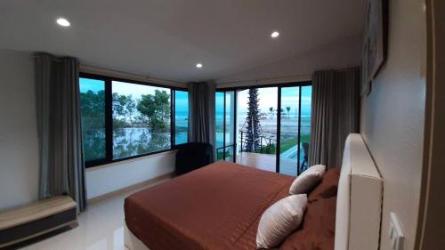 Lom Lay Beach Front Pool Villa Chaam, Huahin في Ban Bo Yai: غرفة نوم مع سرير وإطلالة على المحيط