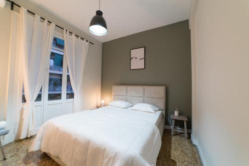 una camera da letto con un grande letto bianco e una finestra di Heart of Athens Thisio ad Atene