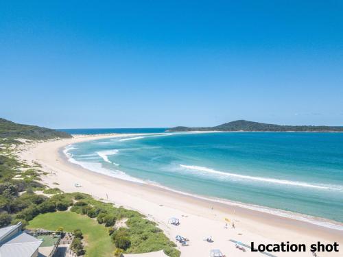 a view of a beach with people and the ocean at Baia Villa air con WiFi and views of Fingal Beach in Fingal Bay