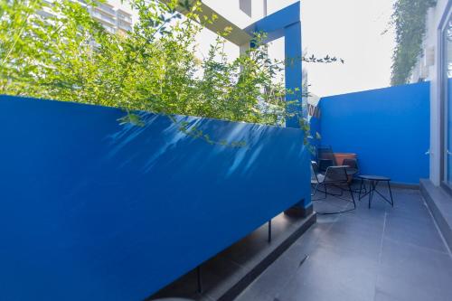 a blue wall on a building with chairs and plants at V65 Mx in Mexico City